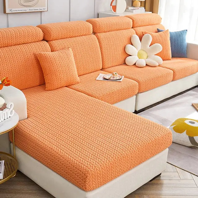 Fundas para sof? de color naranja con textura en forma de V, con cojines a juego, en una sala de estar luminosa y decorada con estilo. Compra disponible en blueemoonco.com, especialistas en fundas para sof?s y sillas.