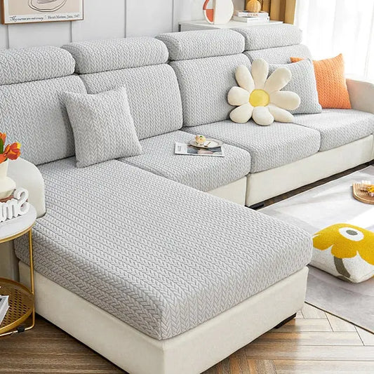 Funda para sof?­ seccional en tonos grises con cojines decorativos en forma de flor y colores vivos, perfecta para salones modernos y acogedores.